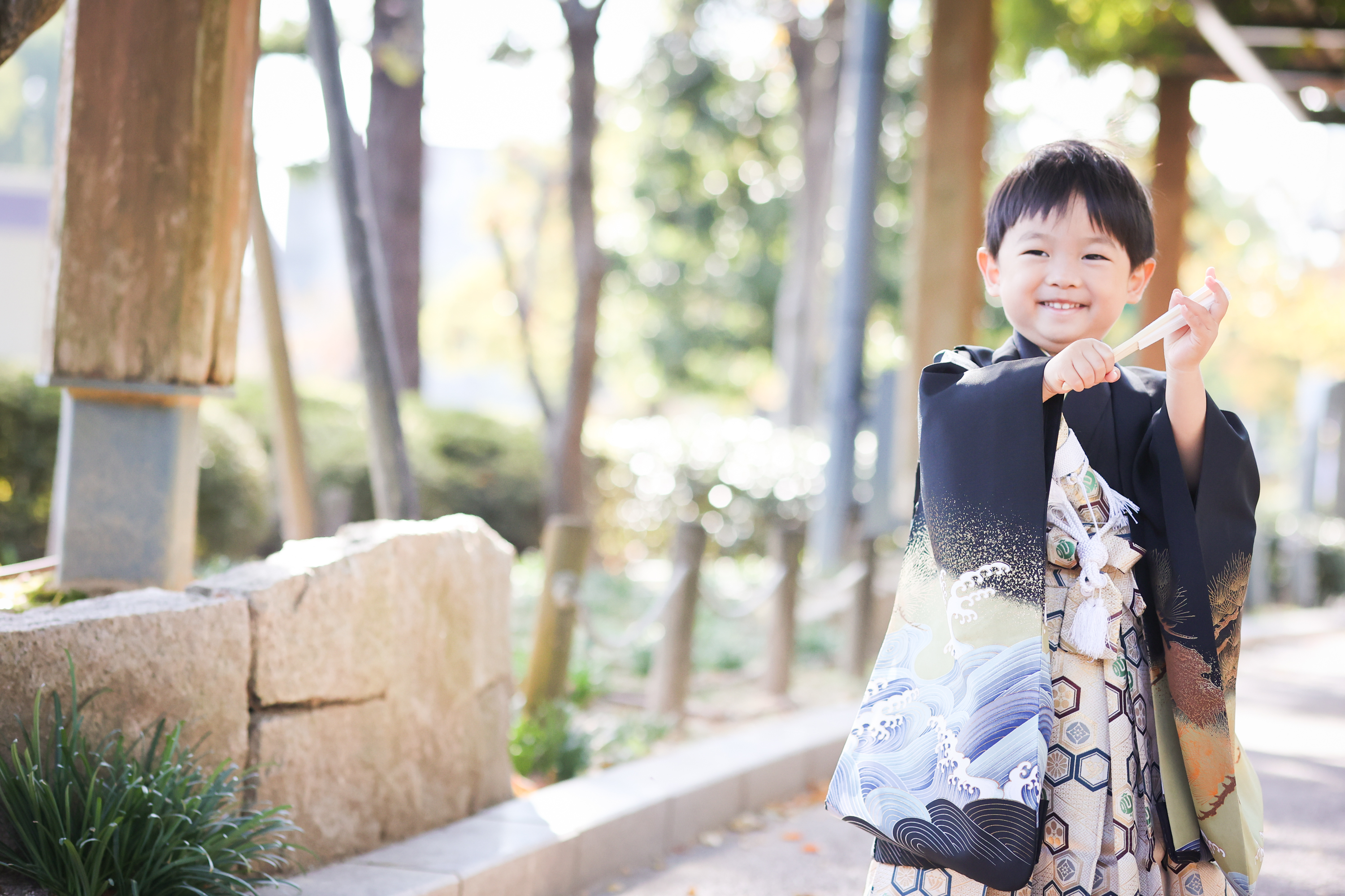 男の子が扇子を手に笑っている画像